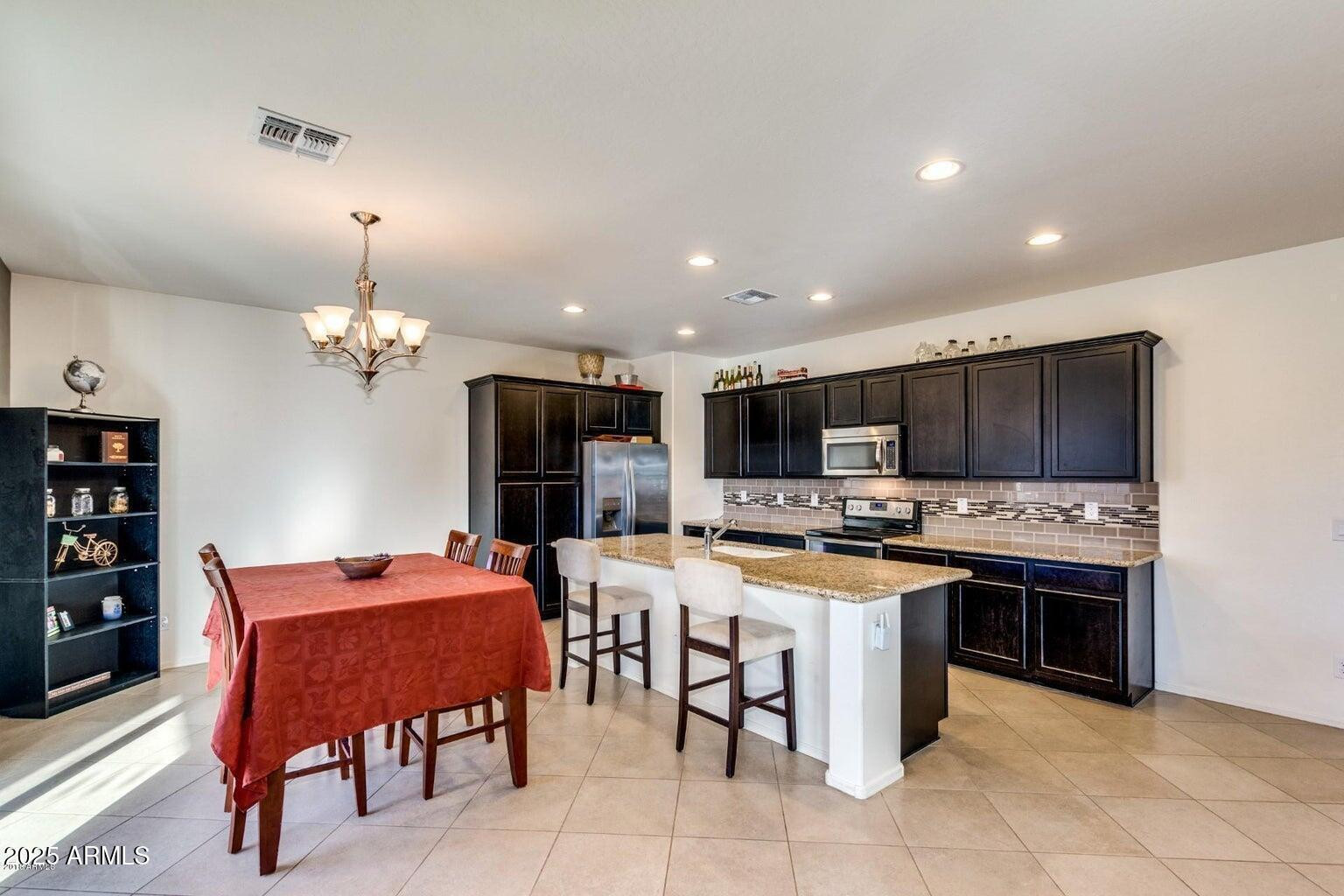 12057 West Rowel Road Peoria, AZ 85383 - Photo 4 of 20 a large kitchen with a table and chairs