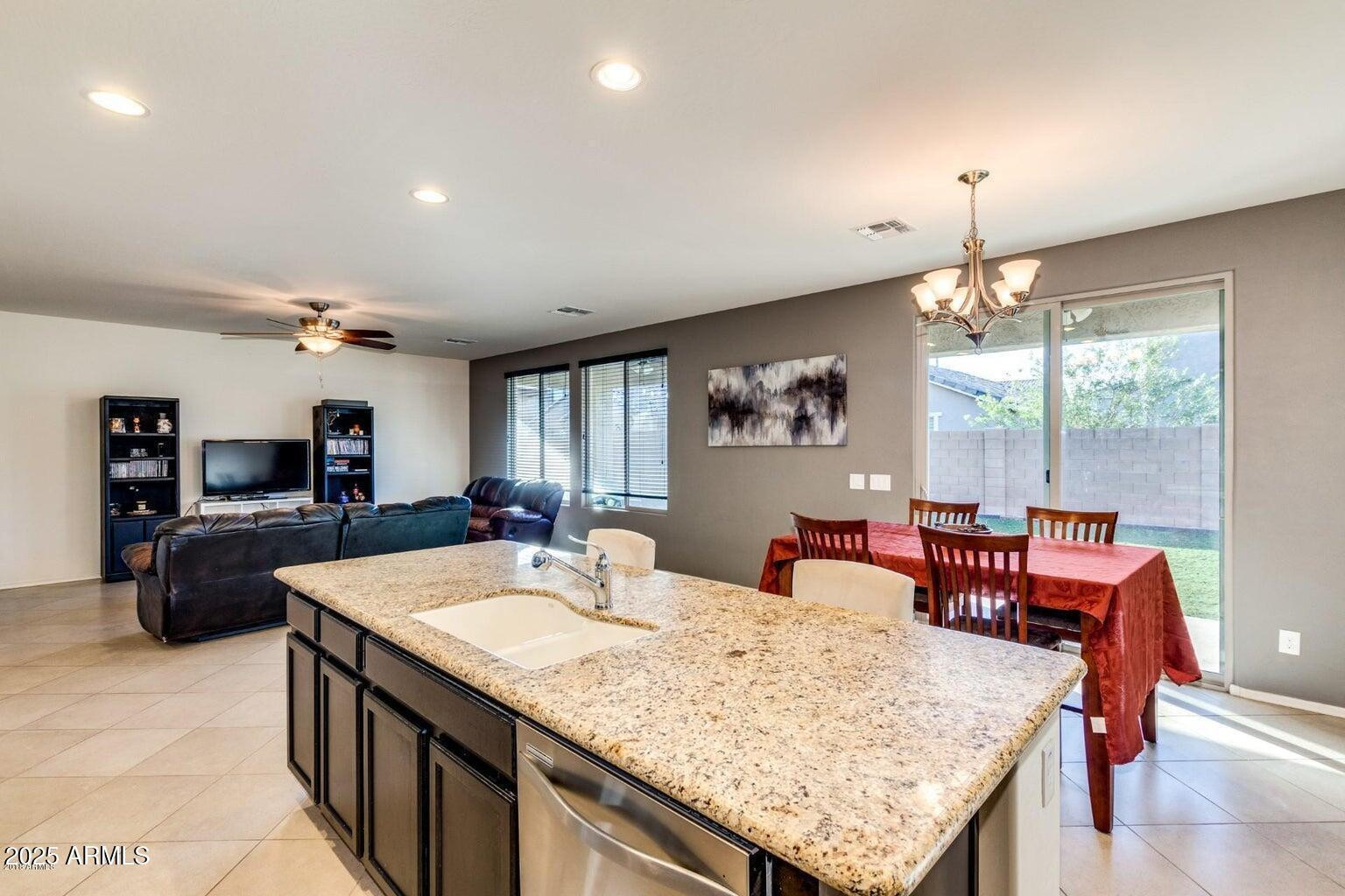 12057 West Rowel Road Peoria, AZ 85383 - Photo 5 of 20 a kitchen with granite countertop a sink counter top space and living room