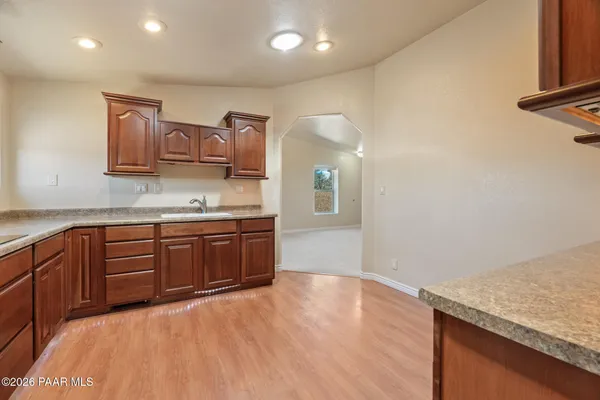 a kitchen with stainless steel appliances granite countertop a sink a stove and a wooden floors