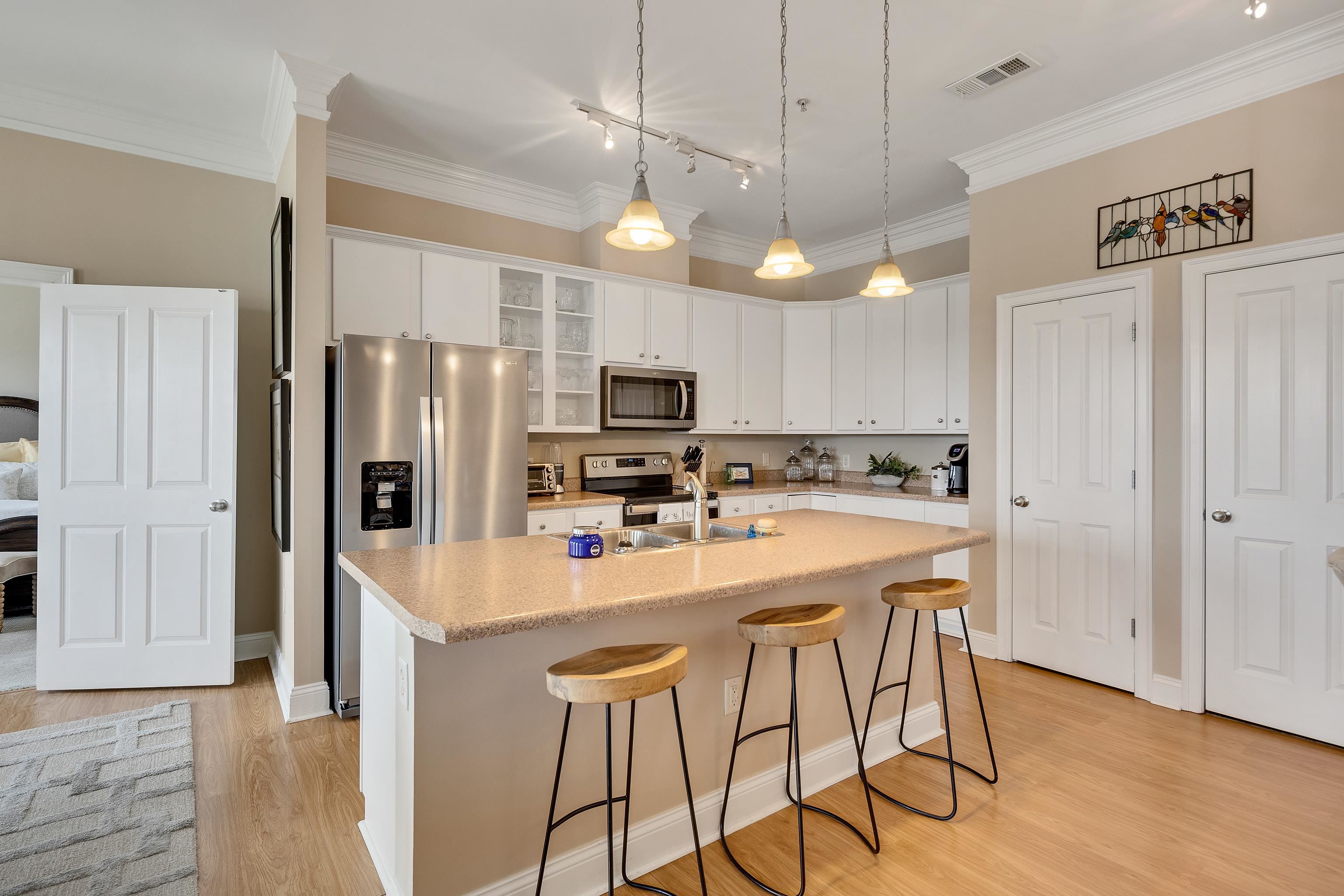 680 Harbor Bend Road, Unit 308 Memphis, TN 38103 - Photo 8 of 31 Kitchen with stainless steel appliances, a kitchen bar, light wood-style floors, light countertops, and crown molding