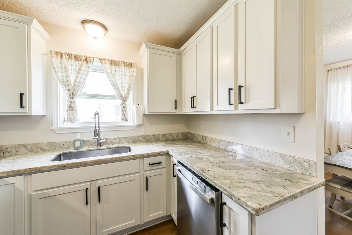 323 Coventry Lane Alvin, TX 77511 - Photo 13 of 37 a kitchen with granite countertop white cabinets and a sink