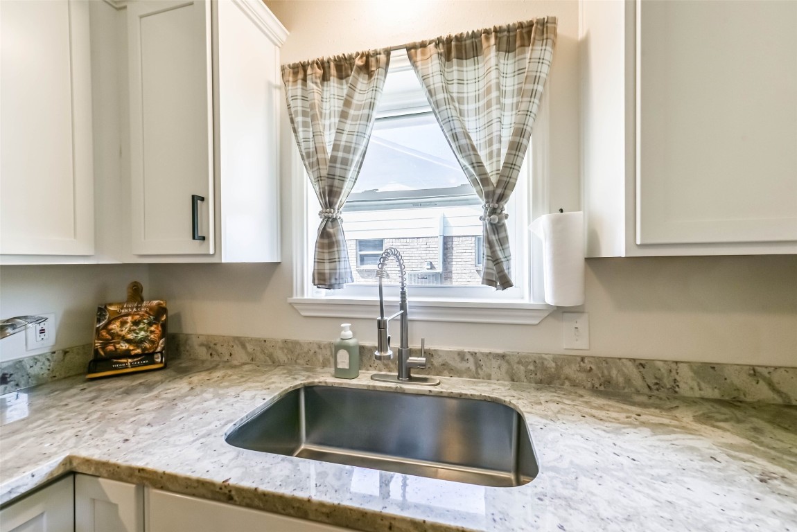 323 Coventry Lane Alvin, TX 77511 - Photo 14 of 37 a kitchen with sink a window and cabinets