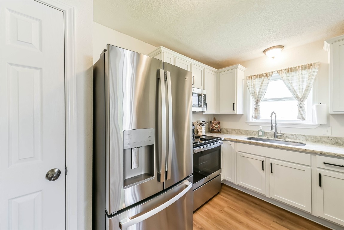 323 Coventry Lane Alvin, TX 77511 - Photo 19 of 37 a kitchen with stainless steel appliances granite countertop a refrigerator and a sink