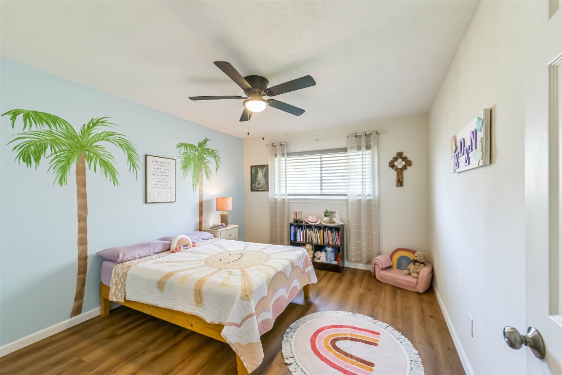 323 Coventry Lane Alvin, TX 77511 - Photo 27 of 37 a bedroom with a bed and a chandelier