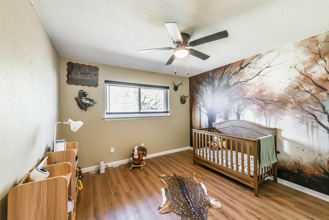 323 Coventry Lane Alvin, TX 77511 - Photo 30 of 37 a view of a bedroom with wooden floor and fan