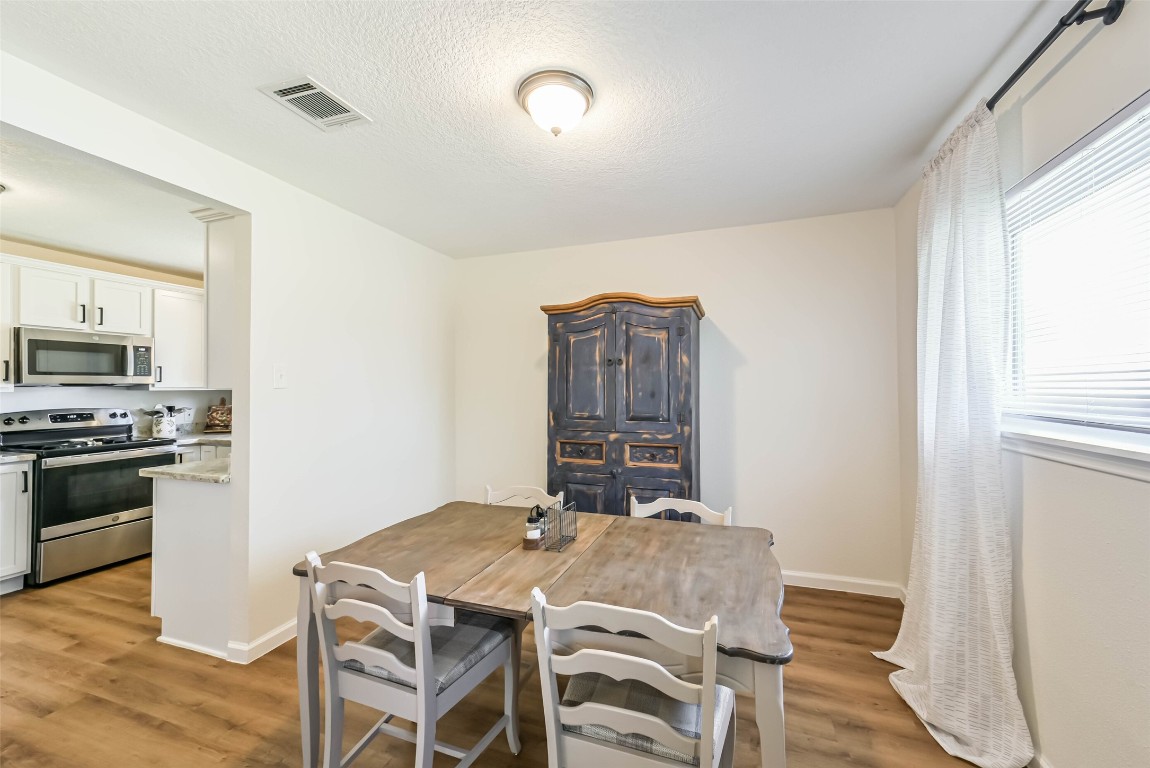 323 Coventry Lane Alvin, TX 77511 - Photo 10 of 37 a view of a dining room with furniture and wooden floor