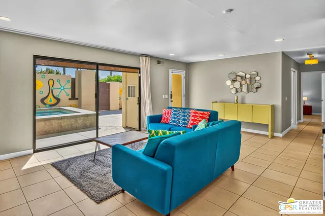 a living room with furniture and a floor to ceiling window