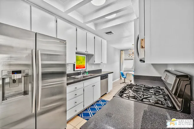 a kitchen with stainless steel appliances granite countertop a stove a sink and a refrigerator