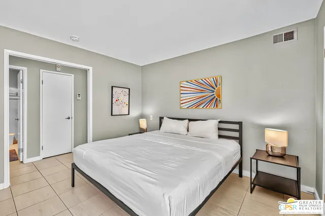 a bedroom with a bed and a lamp on table