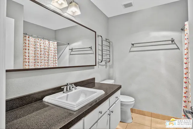 a bathroom with a sink vanity mirror and toilet