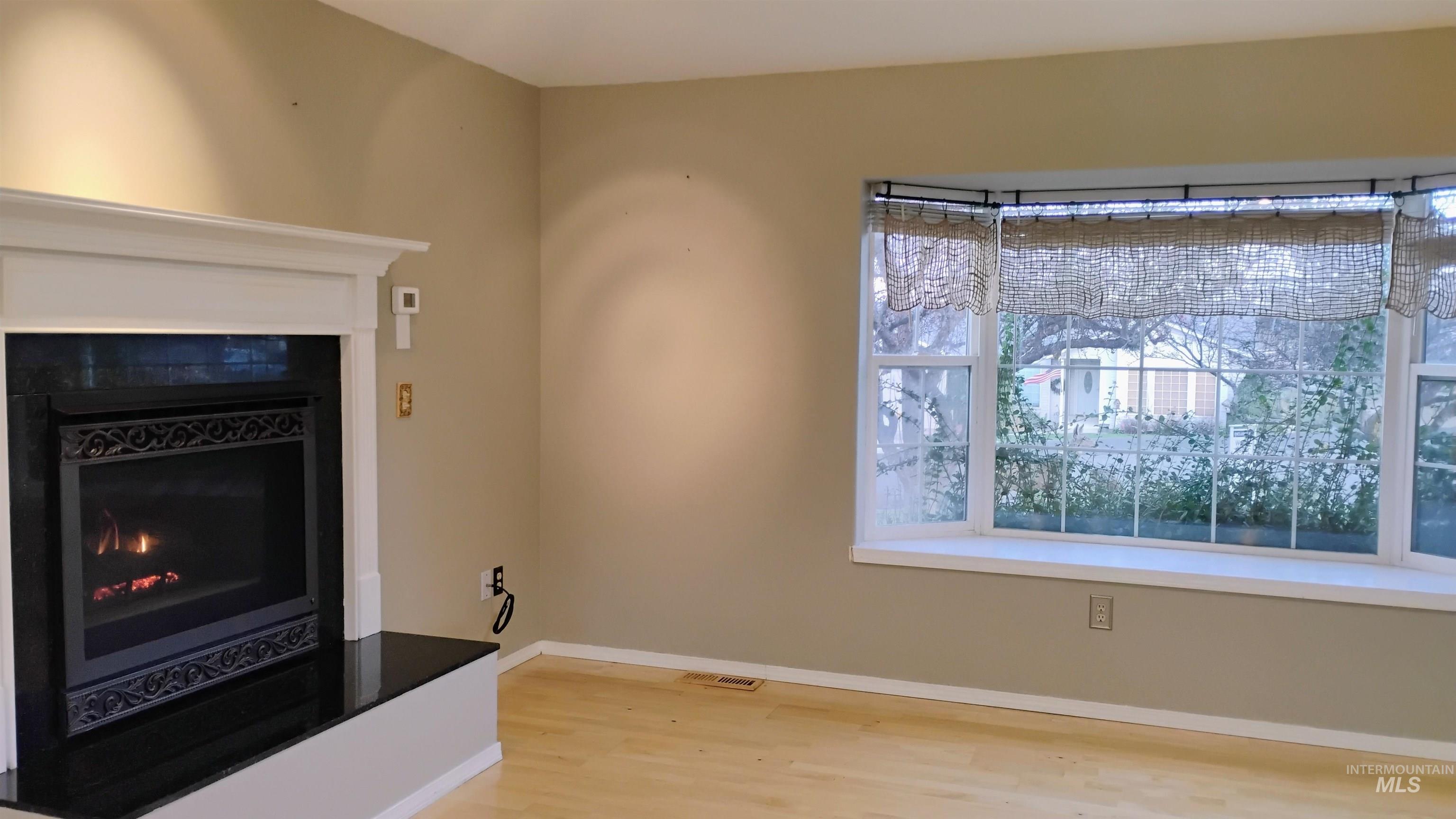 2242 Chukar Lane Clarkston, WA 99403 - Photo 8 of 41 Detailed view of a warm lit fireplace and wood finished floors