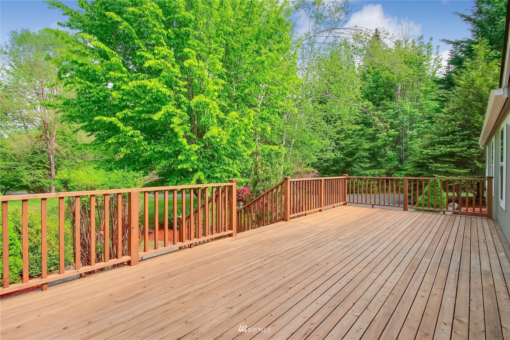 12319 Chain Lake Road Snohomish, WA 98290 - Photo 4 of 38 a balcony with wooden floor and trees in the background