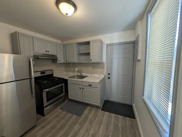 a kitchen with sink a refrigerator and cabinets