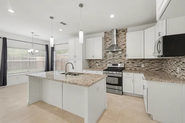 a kitchen with stainless steel appliances granite countertop a sink stove and cabinets