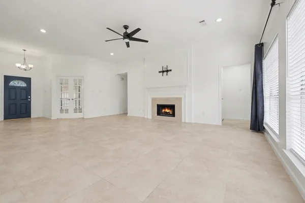 a view of an empty room with a fireplace and a window