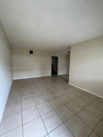 a view of a livingroom with wooden floor and a bathroom