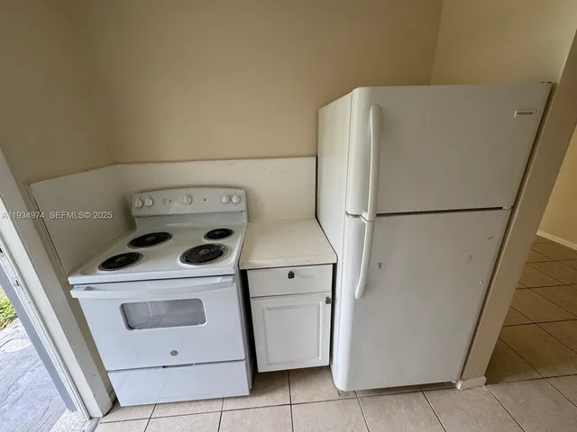 a kitchen with a refrigerator a stove top oven and a stove