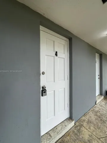 a view of a hallway with wooden floor and a bathroom