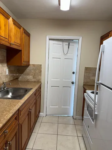 a kitchen with granite countertop a sink and a stove
