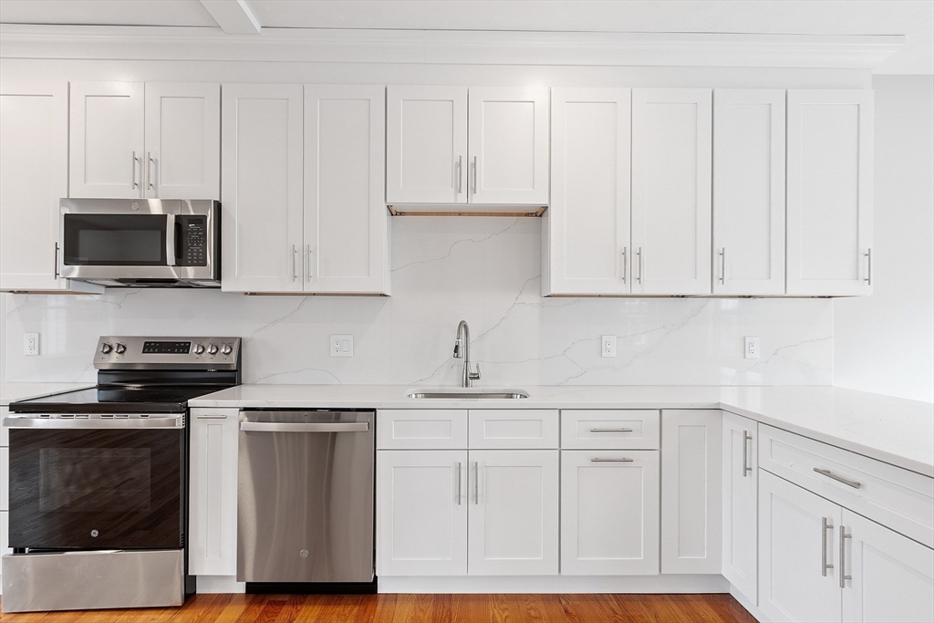 10 Windsor Street Worcester, MA 01605 - Photo 3 of 26 a kitchen with white cabinets and appliances