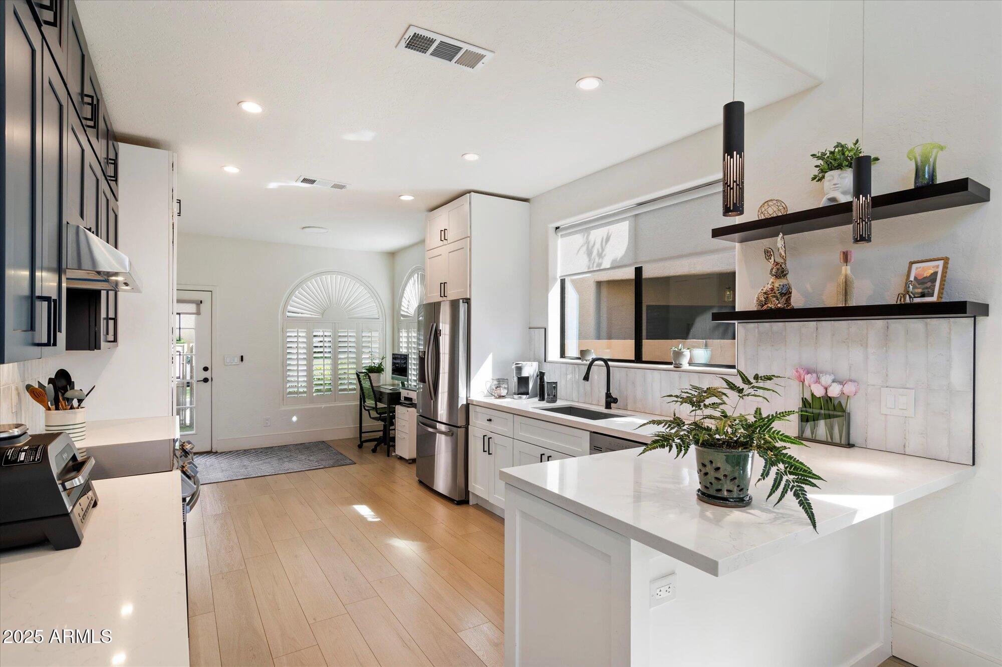 11846 North 40th Place Phoenix, AZ 85028 - Photo 10 of 37 a kitchen with stainless steel appliances kitchen island granite countertop a sink and cabinets