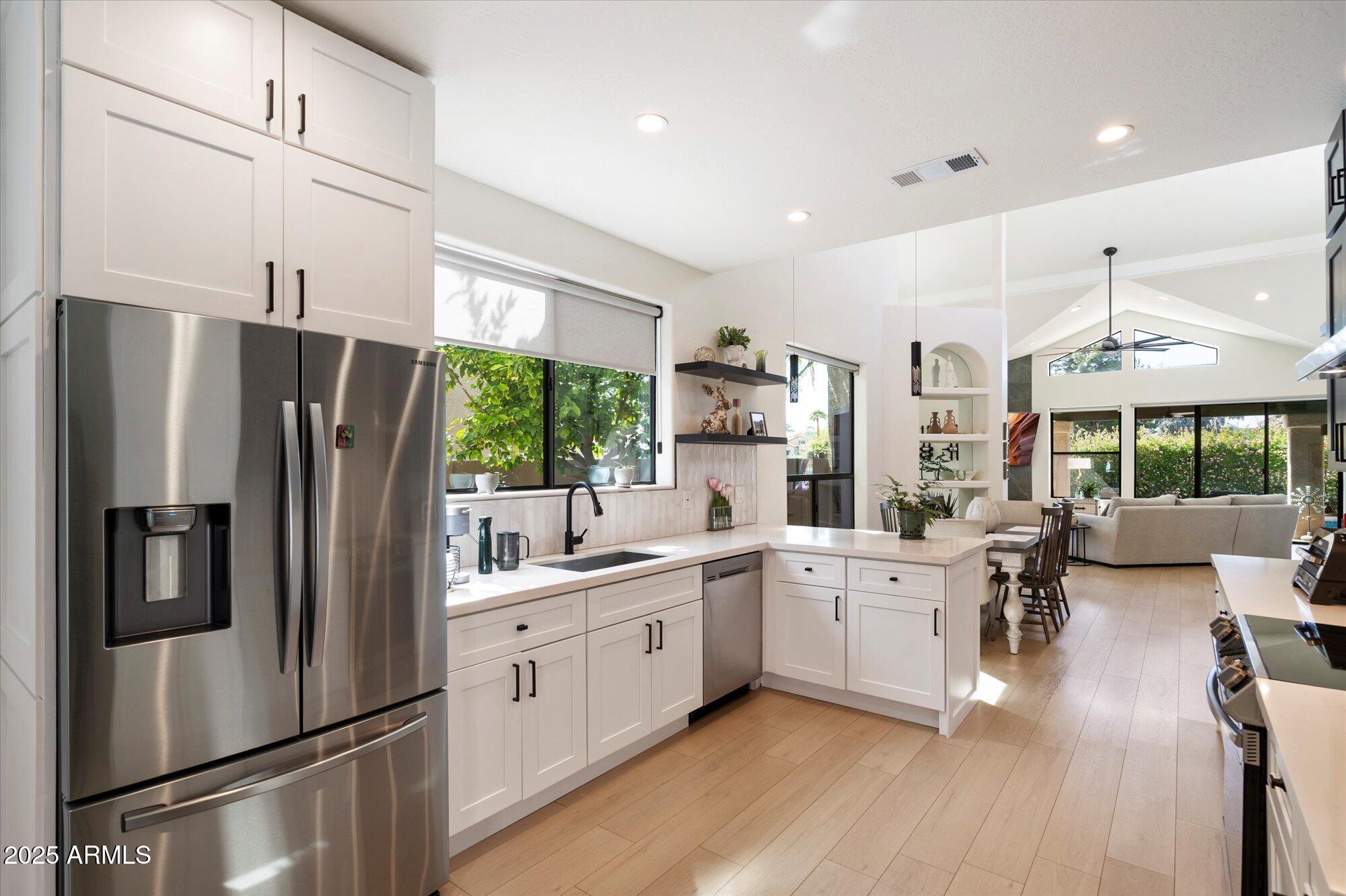 11846 North 40th Place Phoenix, AZ 85028 - Photo 11 of 37 a kitchen with white cabinets and stainless steel appliances