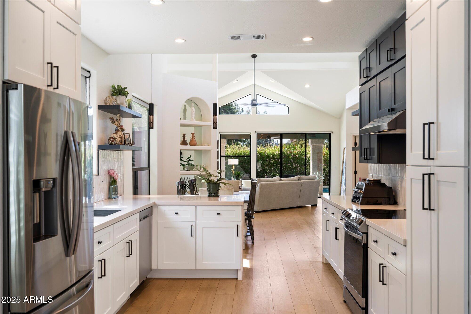 11846 North 40th Place Phoenix, AZ 85028 - Photo 12 of 37 a kitchen with stainless steel appliances kitchen island granite countertop a refrigerator a oven a stove and a sink with wooden floor