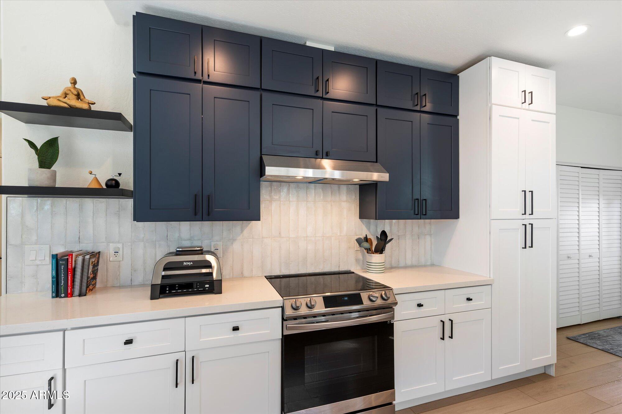 11846 North 40th Place Phoenix, AZ 85028 - Photo 13 of 37 a kitchen with stainless steel appliances a stove a refrigerator and cabinets