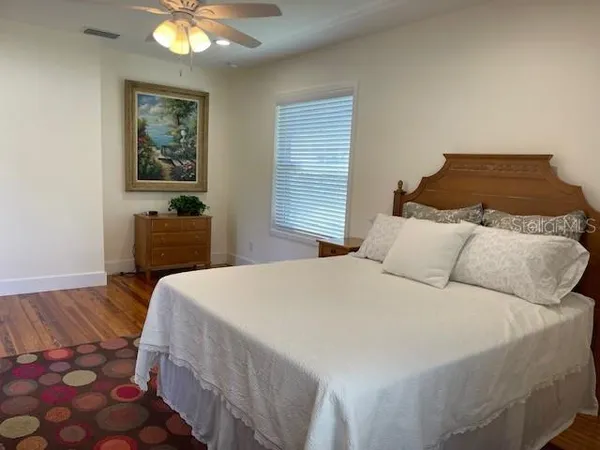 a bedroom with a bed and a lamp on dresser