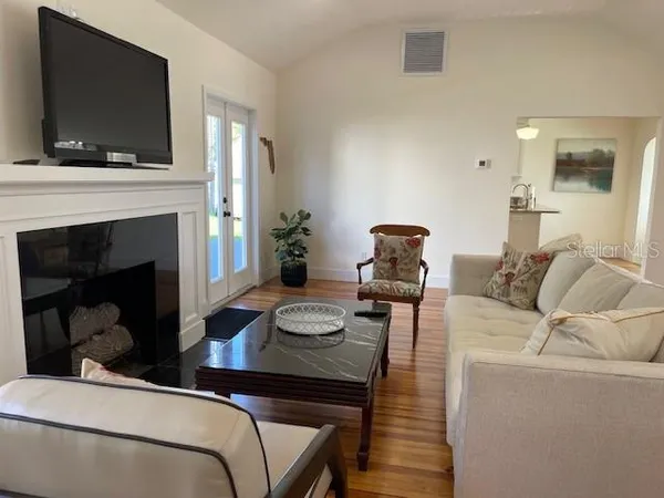 a living room with furniture a flat screen tv and a fireplace