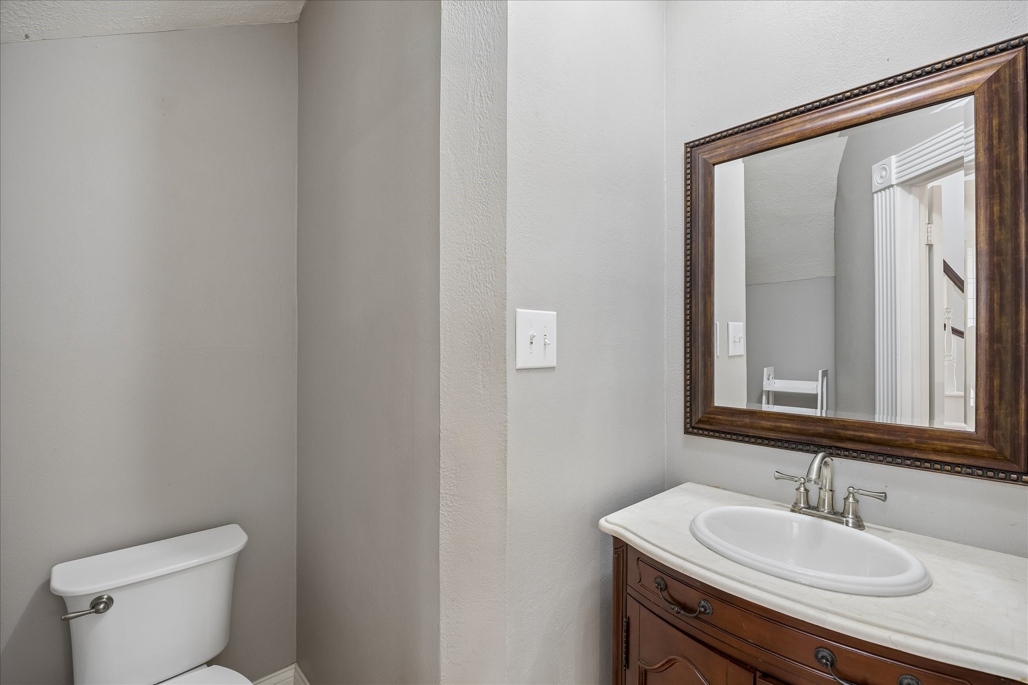 7915 Huddersfield Court Spring, TX 77379 - Photo 35 of 37 Convenient powder bath on the main level with a furniture-style vanity, framed mirror, and easy access from the foyer and living areas.