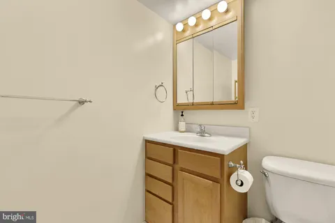 a bathroom with a toilet sink vanity and mirror