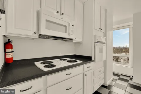 a kitchen with white cabinets and appliances