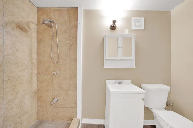 a bathroom with a toilet sink shower and mirror