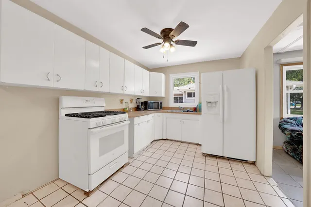 a kitchen with white cabinets and white appliances