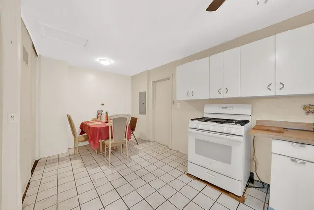 a kitchen with a stove a sink and white cabinets