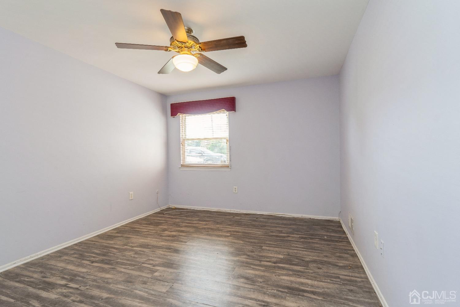 39 Haven Drive Old Bridge, NJ 07747 - Photo 14 of 16 an empty room with wooden floor and ceiling fan