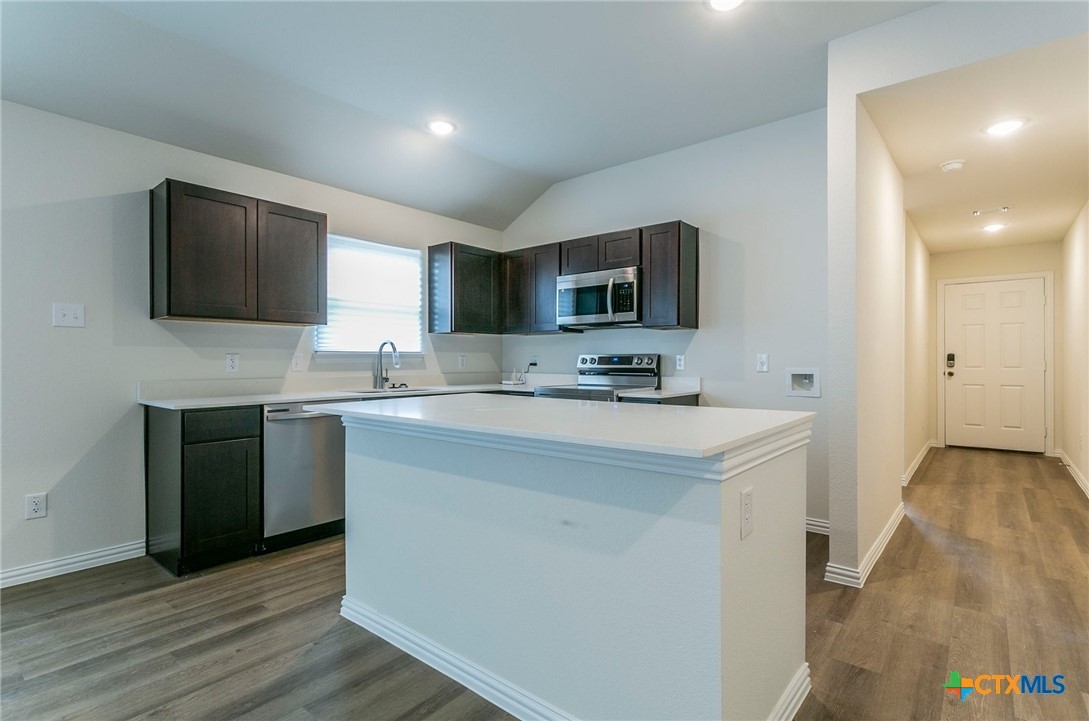 3009 Gillespie Court Temple, TX 76501 - Photo 5 of 13 a kitchen with stainless steel appliances a stove top oven a sink a refrigerator white cabinets and wooden floor