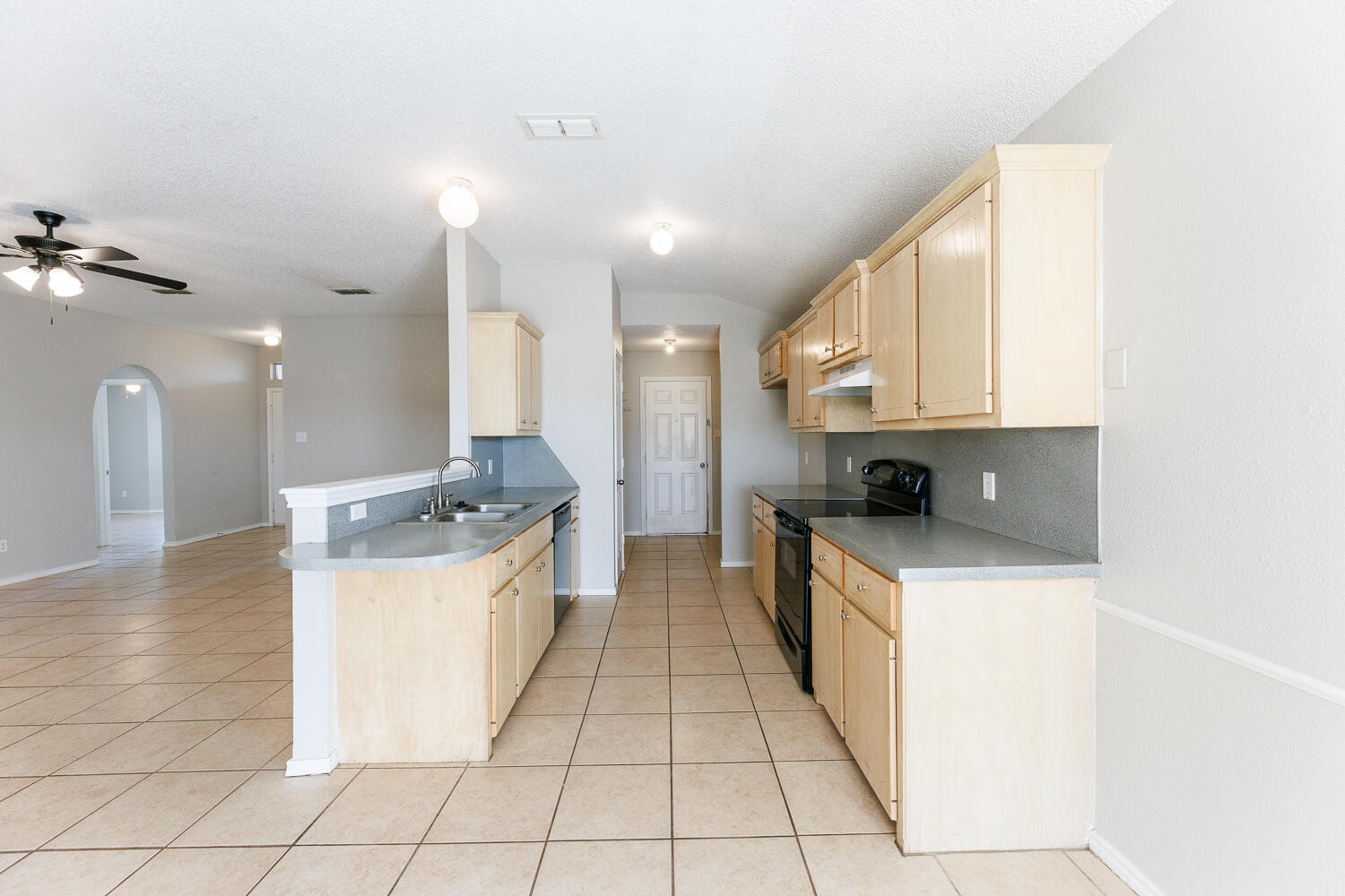 5903 10th Street, Unit 3 Lubbock, TX 79416 - Photo 14 of 32 a large kitchen with stainless steel appliances kitchen island granite countertop a sink and cabinets