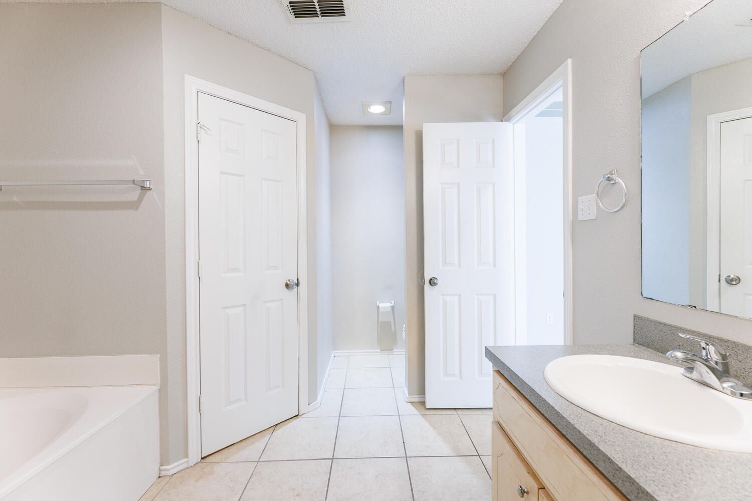 5903 10th Street, Unit 3 Lubbock, TX 79416 - Photo 22 of 32 a spacious bathroom with a granite countertop sink a mirror and a bathtub