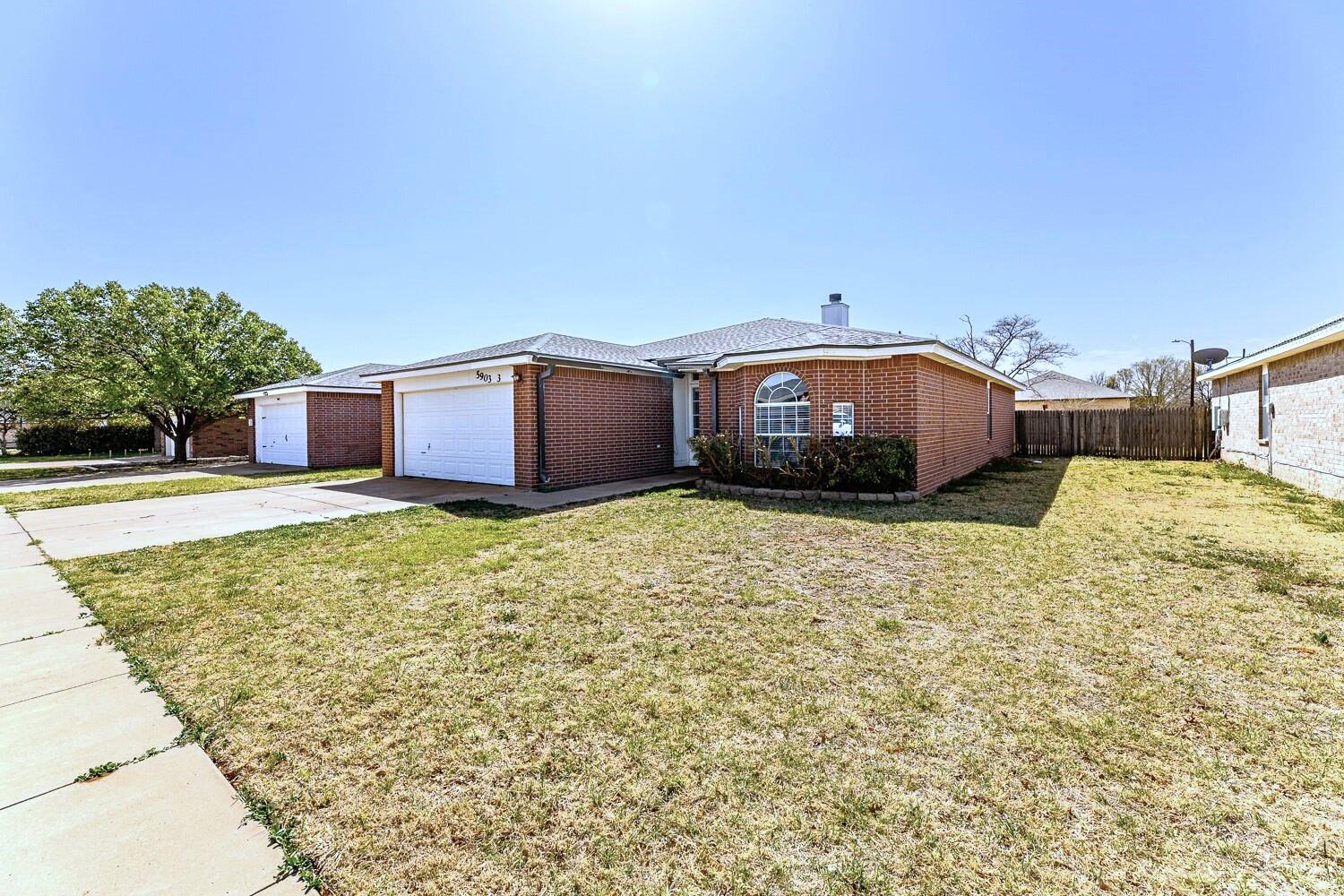 5903 10th Street, Unit 3 Lubbock, TX 79416 - Photo 4 of 32 a front view of a house with a yard