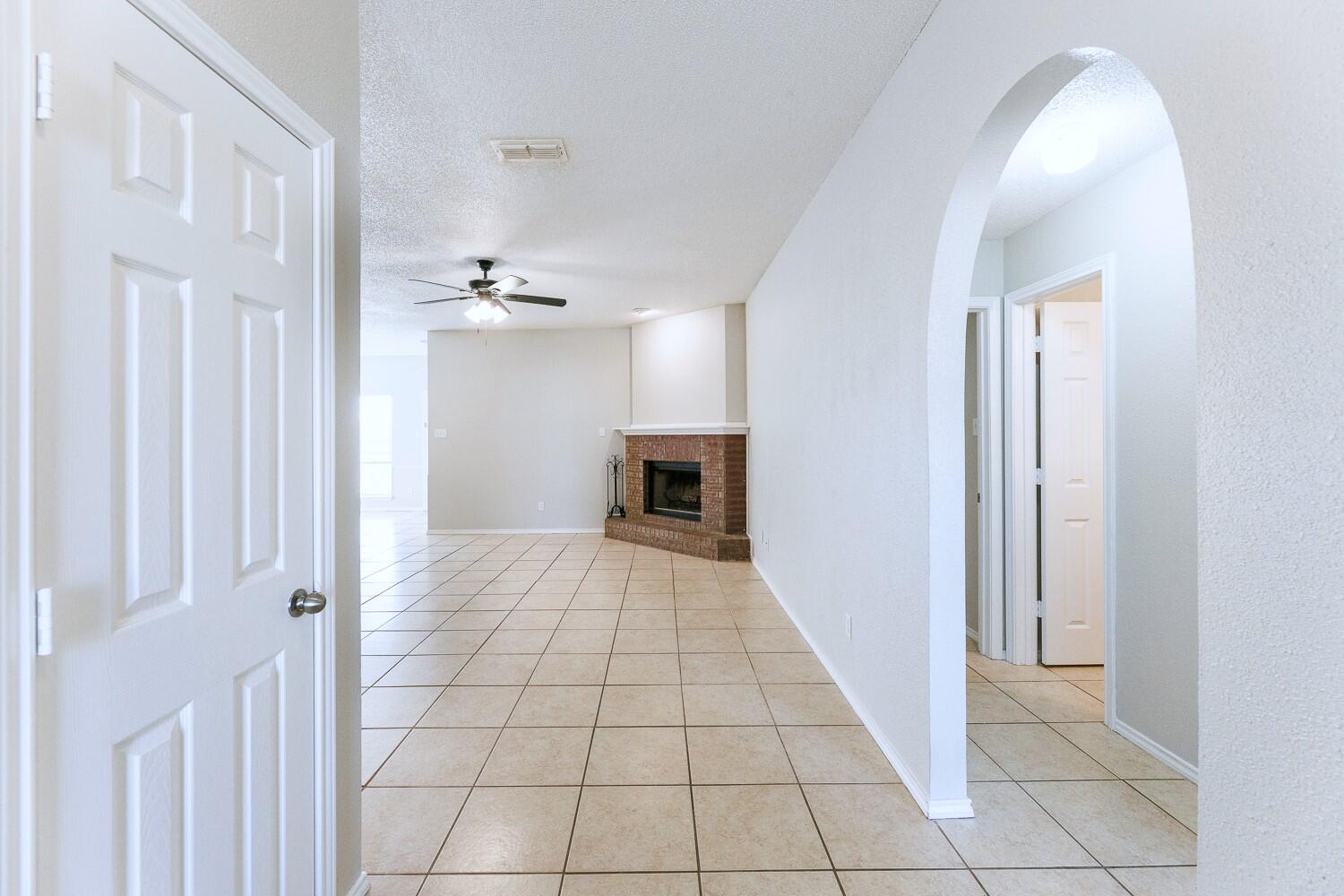 5903 10th Street, Unit 3 Lubbock, TX 79416 - Photo 6 of 32 a view of a hallway with wooden floor and a living room