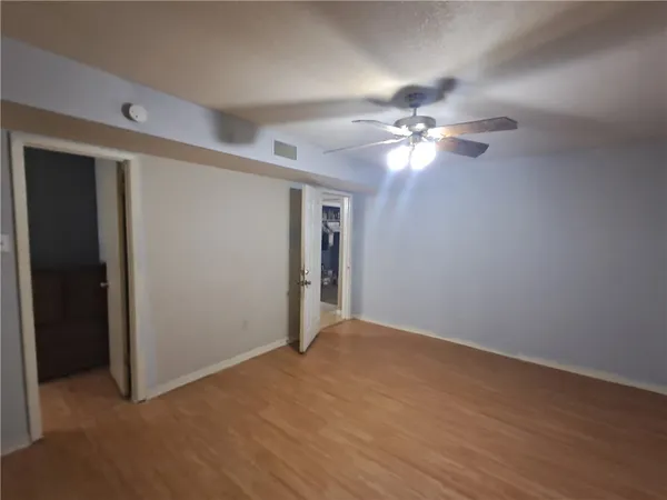 a view of an empty room with a ceiling fan