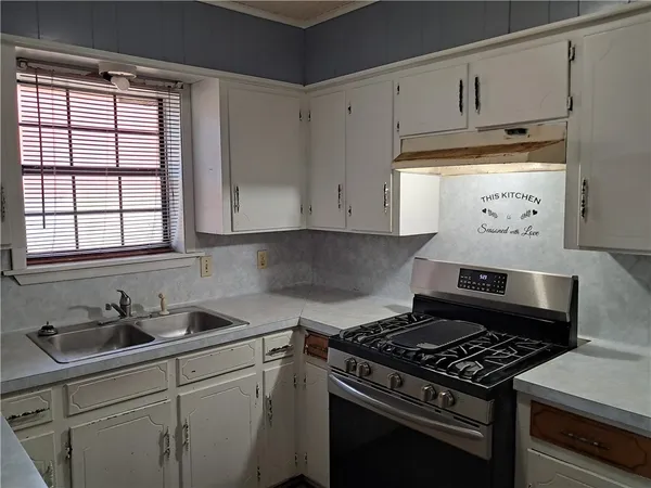 a kitchen with white cabinets and appliances