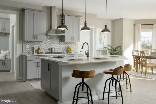 a kitchen with stainless steel appliances a sink a stove a dining table and chairs