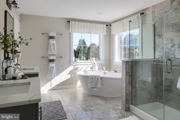 a spacious bathroom with a tub sink and mirror