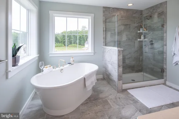 a white bath tub sitting in a bathroom next to a window