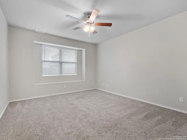 an empty room with windows and fan