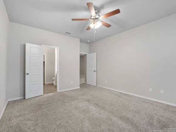 an empty room with a ceiling fan and a window