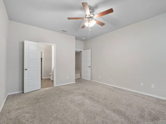 an empty room with a ceiling fan and a window